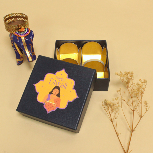Decorative box with 'Happy Diwali' design, gold items inside, and traditional elements on a beige background.
